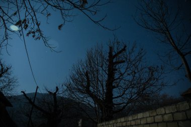 Gece sessiz köyde dolunay var. Ay ışığı altındaki dağ köyünün güzel gece manzarası. Azerbaycan doğası. Uzun pozlu çekim