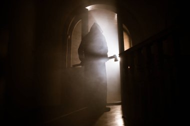 Kapalı cam bir kapıdan geçen, bilinmeyen bir gölge figürünün silueti. Geceleri arka planda duman olan ürkütücü siluet kız.