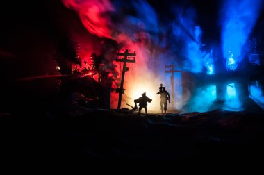 Yangından yaralanmış bir kızı taşıyan bir adamın silüeti. Kurtarıcı konsepti. Savaşta yanmış şehirden gelen bir kadınla kaçan ordu subayı yok edildi. Yaratıcı sanat dekorasyonu. Seçici odak