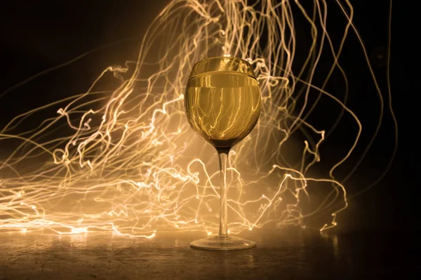 Ahşap masada şarap kadehi ve arka planda güzel renkli ışıklar. Karanlık arka planda şarap kadehleri. Seçici odaklanma. Kulüp içki konsepti