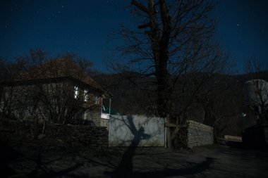 Gece sessiz köyde dolunay var. Ay ışığı altındaki dağ köyünün güzel gece manzarası. Azerbaycan doğası. Uzun pozlu çekim