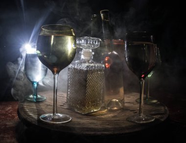 Ahşap masada şarap kadehi ve arka planda güzel renkli ışıklar. Karanlık arka planda şarap kadehleri. Seçici odaklanma. Kulüp içki konsepti