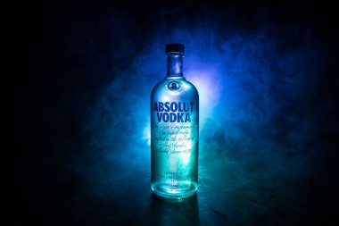 BAKU, AZERBAIJAN - FEB 09, 2020: Absolut Vodka is a brand of vodka, produced near Ahus, in Sweden. Owned by French group Pernod Ricard. Bottle of vodka on wooden table with dark toned foggy background.