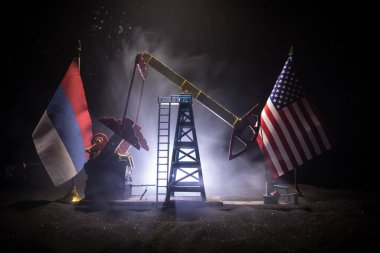 İş diyaloğu, petrol anlaşması konsepti: Geceleri petrol pompası ve petrol rafineri fabrikası olan ulusal bayraklar. Enerji endüstrisi konsepti. Seçici odaklanma. Sanat eseri dekorasyonu.