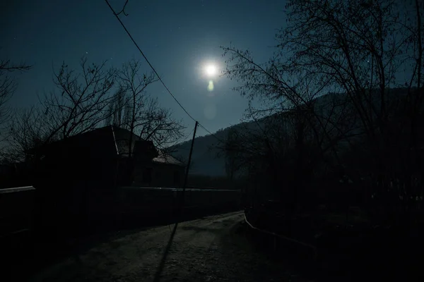 Full moon over quiet village at night. Beautiful night landscape of mountain village under the moonlight. Azerbaijan nature. Long exposure shot