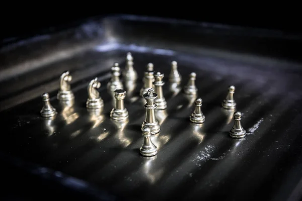 Chess board game concept of business ideas and competition. Chess figures on a dark background with smoke and fog. Selective focus