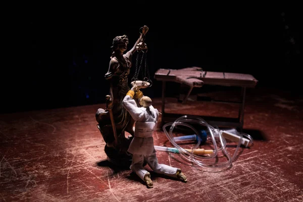 Zehirli iğne konsepti. Mahkûm zehirli iğneyle öldürülerek kelepçelenmiş. Işıklı ve koyu renk ölçekli yaratıcı sanat dekorasyonu.