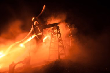 Petrol pompası ve petrol rafineri fabrikası geceleri sis ve arka planda. Enerji endüstrisi konsepti. Seçici odaklanma. Sanat eseri dekorasyonu.