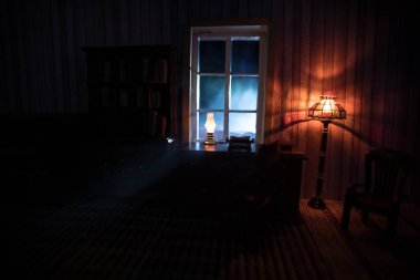 Geceleri mobilyası ve penceresi olan gerçekçi bir bebek evi oturma odası. El yapımı gerçekçi bebek eviyle sanat masası dekorasyonu. Seçici odak.