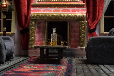 Geceleri mobilyası ve penceresi olan gerçekçi bir bebek evi oturma odası. El yapımı gerçekçi bebek eviyle sanat masası dekorasyonu. Seçici odak.