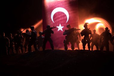 Türk ordusu konsepti. Türk bayrağına karşı silahlı askerlerin silueti. Yaratıcı sanat dekorasyonu. Askeri siluetler dövüş sahnesinde sisli bir arka planda. Seçici odak
