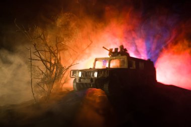 Savaş Konsepti. Savaş sahnesi sisli gökyüzü arka planında geceleri Bulutlu Skyline 'ın altında siluetlerle savaşmak. Askerlerin sanat eserleriyle donatılmış askeri araç. Seçici odak