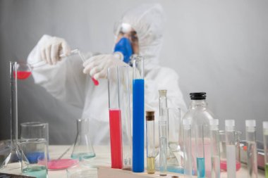 Coronavirus covid 19 elinde cerrahi maskeli ve parlayan bir kadın doktorun enfekte olmuş kan tüpü. Coronavirus covid 19 tedavi laboratuvarı, Coronavirus covid-19 aşı araştırması. Seçici odak