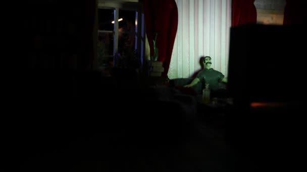 夜には家具や窓のあるリアルな人形の家のリビングルーム 手作りのリアルな人形の家とアートテーブルの装飾 暗い部屋でレトロなスタイルのテレビを着て男 選択的焦点 — ストック動画