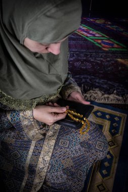 Müslüman bir kadın camide Allah için dua ediyor. Halıda dua eden Müslüman kadının elleri geleneksel kıyafetlerle, tesettürlü kadının elleri..
