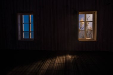 Karanlık odanın penceresinden Ay 'ın gece manzarası görülüyor. Gerçekçi bebek evi minyatür dekore edilmiş. Ay ışığı karanlık odada.