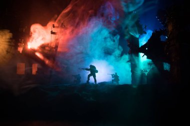 Büyük kalibreli tüfekli ordu keskin nişancısı ateş ve dumanın içinde duruyor. Savaş Konsepti. Savaş sahnesi sisli gökyüzü arka planında geceleri Bulutlu Skyline 'ın altında siluetlerle savaşmak. Şehir savaş yüzünden yok oldu.