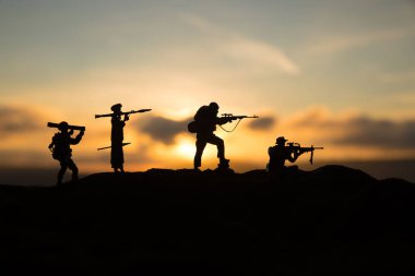 Askeri askerler bazuka ve roketatarlı siluetler. Savaş Konsepti. Askeri siluetler savaş sisli gökyüzü arka planında savaş sahnesi, RPG ile Mojahed ve güneş batarken bazukalı biz askerler. Saldırı sahnesi