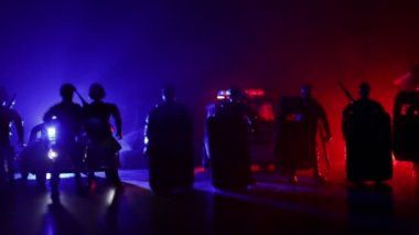 Corona virüsünün polisle olan görüntüsü. Corona virüsünü önlemek için tedbir amaçlı önlemler için evde kal. Çevik kuvvet polisi hazır olmak için işaret verdi. Işıklı, karanlık bir arka planda sigara içmek.
