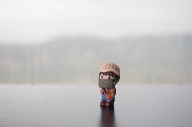 Minyatür insanlar: Virüslerden korunmak için maske takan vatandaşlar. İnsanlar yeni tip COVID-19 zatürreeyi önlemek için maske takıyor. Coronavirus ve Covid-19 konsepti. Seçici odak