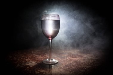 Ahşap masada şarap kadehi ve arka planda güzel renkli ışıklar. Karanlık arka planda şarap kadehleri. Seçici odaklanma. Kulüp içki konsepti