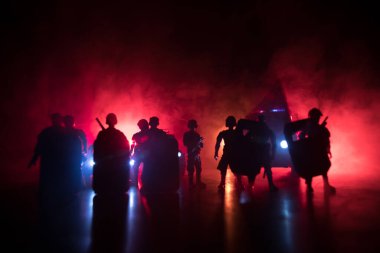 Polisle Corona virüsü konsepti. Corona virüsünü önlemek için tedbir amaçlı önlemler için evde kal. Çevik kuvvet polisi hazır olmak için işaret verdi. Karanlık arka planda ışıklarla tüttürmek. Seçici odak