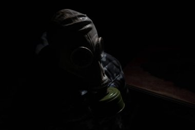Çevre felaketi. Karanlık bir arka planda gaz maskeli kıyamet sonrası hayatta kalan biri. Gaz maskesi takan bir adamın dramatik portresi. Radyasyon koruması demek. Seçici odak
