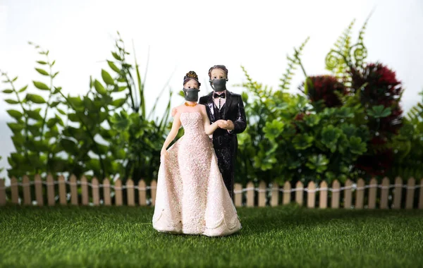 Miniature people : Happy bride wearing masks to protect against viruses during wedding time. People wear masks to prevent New type COVID-19 pneumonia. Coronavirus and Covid-19 concept. Selective focus