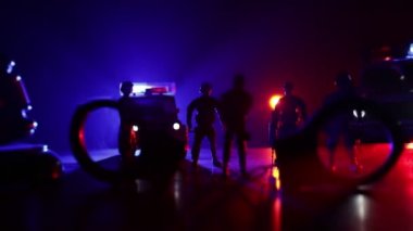 Corona virüsünün polisle olan görüntüsü. Corona virüsünü önlemek için tedbir amaçlı önlemler için evde kal. Çevik kuvvet polisi hazır olmak için işaret verdi. Işıklı, karanlık bir arka planda sigara içmek.