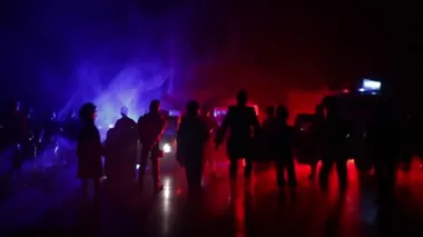Corona virüsünün polisle olan görüntüsü. Corona virüsünü önlemek için tedbir amaçlı önlemler için evde kal. Çevik kuvvet polisi hazır olmak için işaret verdi. Işıklı, karanlık bir arka planda sigara içmek.