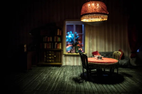 A realistic dollhouse living room with furniture and window at night. Stay home stay safe coronavirus concept. Selective focus.