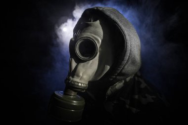 Çevre felaketi. Karanlık bir arka planda gaz maskeli kıyamet sonrası hayatta kalan biri. Gaz maskesi takan bir adamın dramatik portresi. Radyasyon koruması demek. Seçici odak