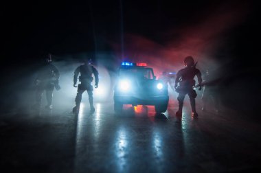Polisle Corona virüsü konsepti. Corona virüsünü önlemek için tedbir amaçlı önlemler için evde kal. Çevik kuvvet polisi hazır olmak için işaret verdi. Karanlık arka planda ışıklarla tüttürmek. Seçici odak