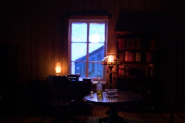 Geceleri mobilyası ve penceresi olan gerçekçi bir bebek evi oturma odası. El yapımı gerçekçi bebek eviyle sanat masası dekorasyonu. Seçici odak.