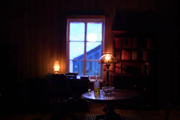 A realistic dollhouse living room with furniture and window at night. Artwork table decoration with handmade realistic dollhouse. Selective focus.