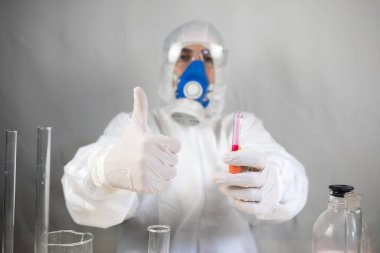 Coronavirus covid 19 elinde cerrahi maskeli ve parlayan bir kadın doktorun enfekte olmuş kan tüpü. Coronavirus covid 19 tedavi laboratuvarı, Coronavirus covid-19 aşı araştırması. Seçici odak