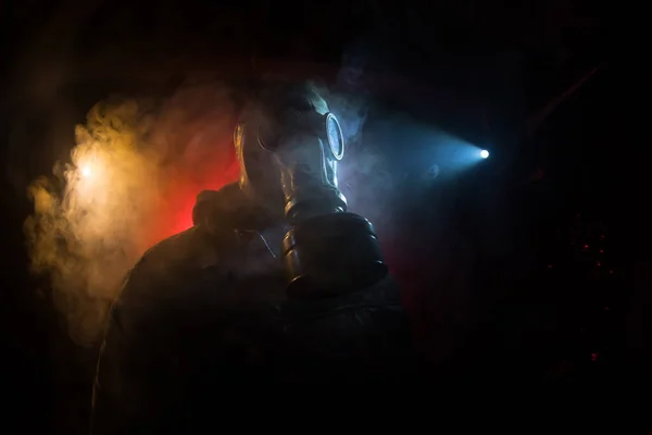 Environmental disaster. Post-apocalyptic survivor in gas mask on a dark background. Dramatic portrait of a man wearing a gas mask. Means for radiation protection. Selective focus