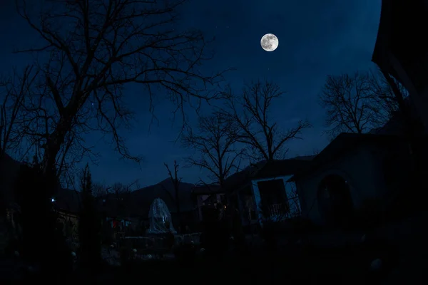 Full moon over quiet village at night. Beautiful night landscape of mountain village under the moonlight. Azerbaijan nature. Long exposure shot