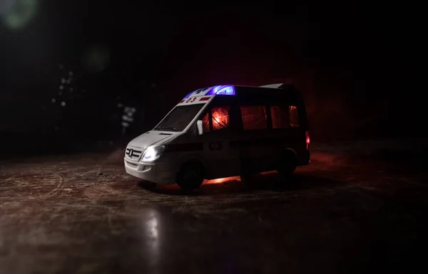 Corona virus concept with Ambulance car. Stay home for precautionary measures to prevent from corona virus. Ambulance car on dark misty background. Creative artwork decoration. Selective focus