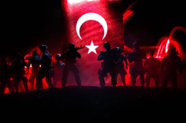 Türk ordusu konsepti. Türk bayrağına karşı silahlı askerlerin silueti. Yaratıcı sanat dekorasyonu. Askeri siluetler dövüş sahnesinde sisli bir arka planda. Seçici odak