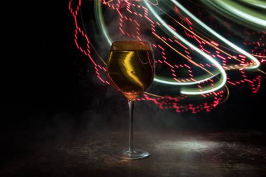 Ahşap masada şarap kadehi ve arka planda güzel renkli ışıklar. Karanlık arka planda şarap kadehleri. Seçici odaklanma. Kulüp içki konsepti