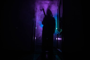 Kapalı cam bir kapıdan geçen, bilinmeyen bir gölge figürünün silueti. Geceleri arka planda duman olan ürkütücü siluet kız.