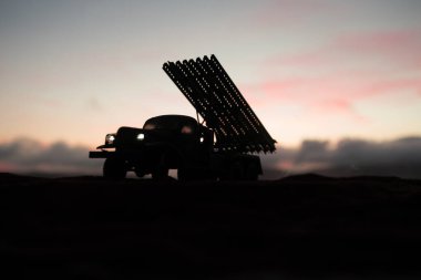 Ateş bulutlu roket fırlatma. Gün batımında Kasvetli Gökyüzünü hedef alan roketli füzelerle savaş sahnesi. Sovyet roket fırlatıcısı Savaş Arkaplanda. Yaratıcı bileşim.