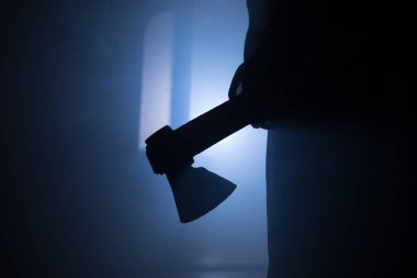Geceleri arka planda duman olan ürkütücü siluet kız. Yaşlı baltayı tutan korkunç kadın. Seçici odak