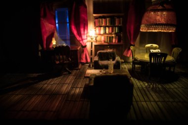 Geceleri mobilyası ve penceresi olan gerçekçi bir bebek evi oturma odası. El yapımı gerçekçi bebek eviyle sanat masası dekorasyonu. Seçici odak.
