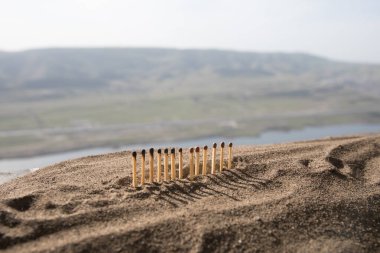 Corona virüsü salgınının yayılmasını nasıl durduracağını gösteren sosyal uzaklık kavramı. Daha uzun mesafeli bir maç seçici odak noktalarının yanmasını durdurur. Gün batımı arkaplanı