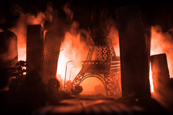 Empty street of burnt up city, flames on the ground and blasts with smoke in the distance. Apocalyptic view of city downtown as disaster film poster concept. Night scene. City destroyed by war.