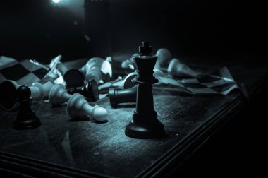 Satranç masası iş fikirleri ve rekabet konsepti. Kırık satranç tahtasıyla karanlık bir arka planda satranç figürü. Yaratıcı sanat dekorasyonu. Seçici odak