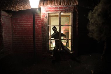 Koronavirüs karantinası sırasında üzgün ve depresif bir adam evde kalıyor, deliriyor ve çıldırıyor. Covid-19 ev izolasyonu konsepti. Gerçekçi bebek evi sanat dekorasyonu. Seçici odak