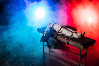 Zehirli iğne konsepti. Mahkûm zehirli iğneyle öldürülerek kelepçelenmiş. Işıklı ve koyu renk ölçekli yaratıcı sanat dekorasyonu.